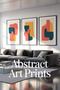 Modern living room with gray sofa, abstract art prints on wall, and sunlight streaming in through large windows.