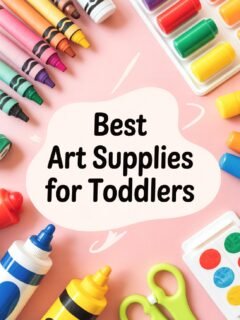 Colorful art supplies for toddlers on a pink surface, including crayons, paint, and scissors.